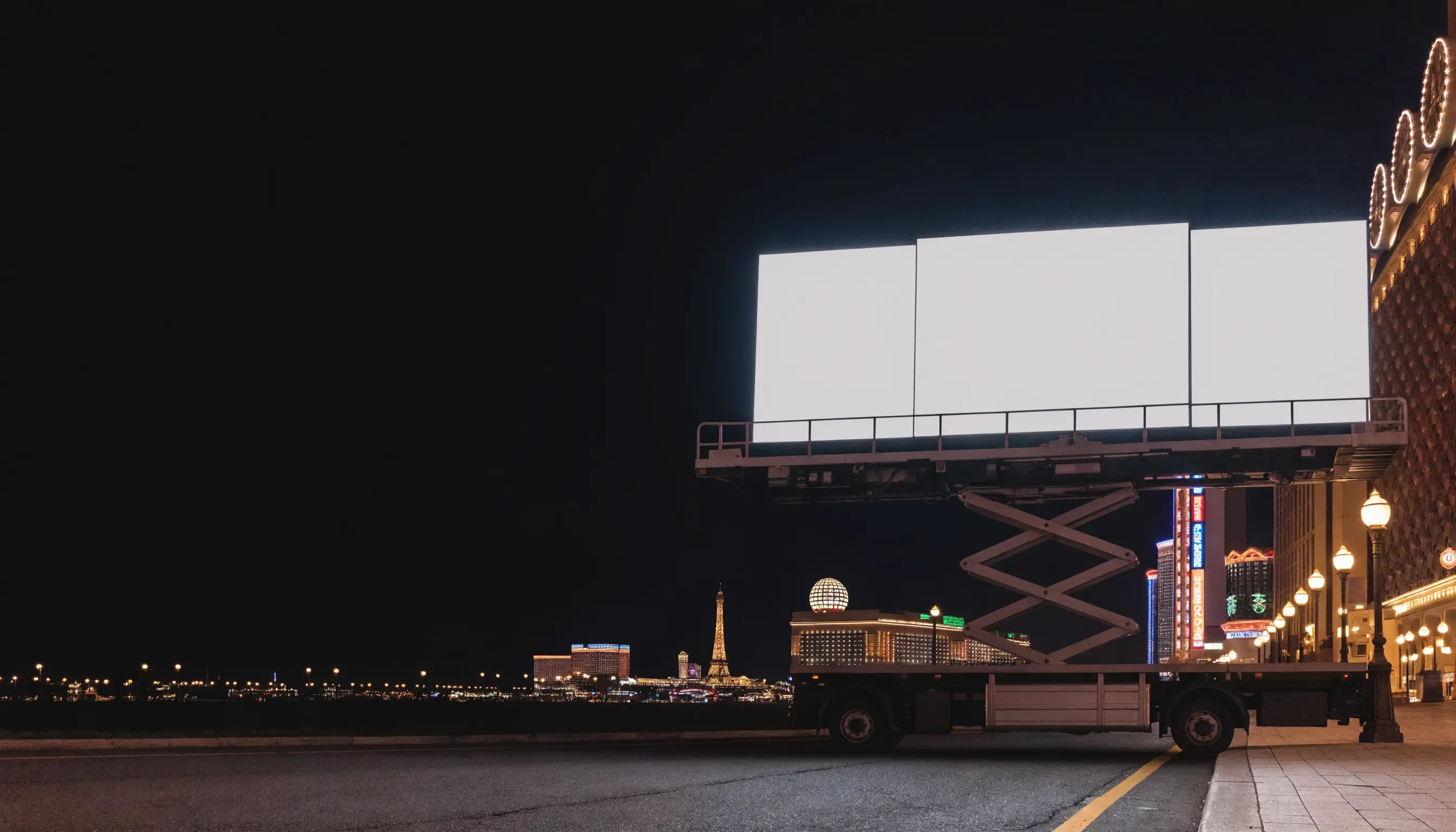 FTL Tri-Fold mobile LED billboard truck with a flat three-panel LED screen raised on a hydraulic lift on the Las Vegas Strip at night